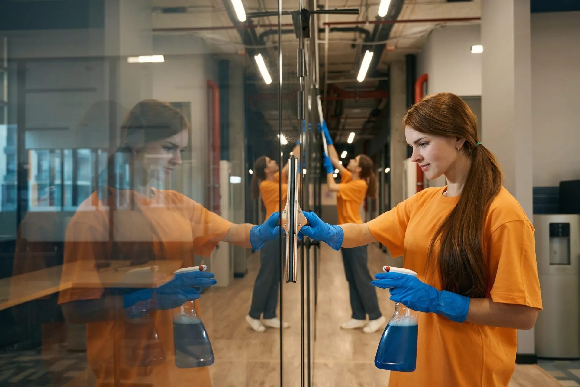 Cleaners polishing glass in a commercial building in Cambridge